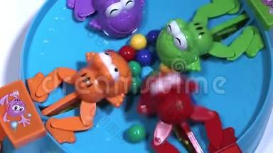 用<strong>彩色球</strong>喂养四只饥饿的塑料青蛙。 儿童游戏关于收集球的速度。